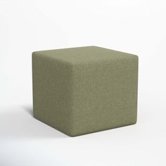 a green cube sitting on top of a white floor