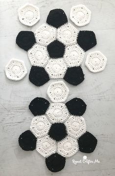 black and white crocheted rugs with circles on them, sitting on a table