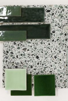 green and white tiles are arranged on the wall in an artistic manner with different shapes