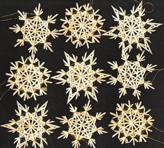 several wooden snowflakes are arranged on a black background