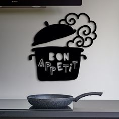 a frying pan sitting on top of a stove next to a sign that says don't appetit