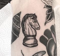 a black and white photo of a tattoo with a chess piece on it's arm