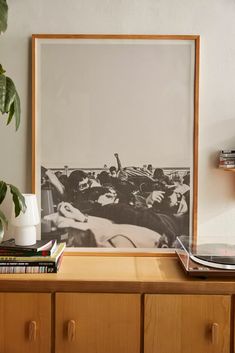 there is a black and white photo on the wall next to a shelf with books