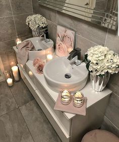 a bathroom vanity with candles and flowers on it