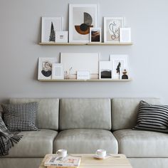 a living room filled with furniture and framed pictures on the wall above a coffee table