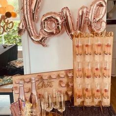 there is a table with champagne glasses and balloons on it, along with the word love spelled out in large letters