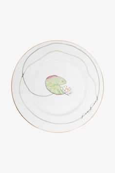 a white and green plate with a frog on it's side in the center