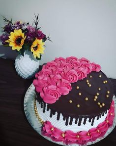 a chocolate cake with pink frosting and flowers