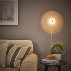 a living room with a couch, table and lamp on the wall next to it