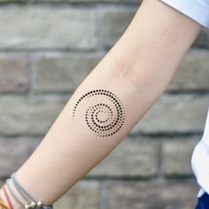 a woman's arm with a tattoo on it that has an image of a spiral