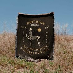 a blanket that is in the grass with a skeleton on it and words written below