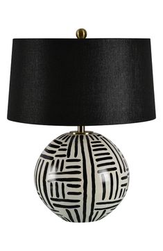 a table lamp with a black shade on the base and a white patterned ball underneath it