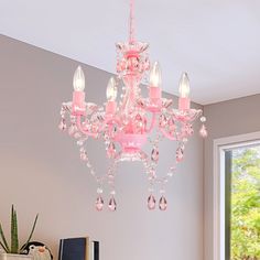 a pink chandelier hanging from the ceiling in a room with a large window