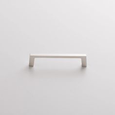 an image of a white door handle on a plain surface with minimal lines and shapes