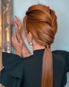 a woman with long red hair in a ponytail