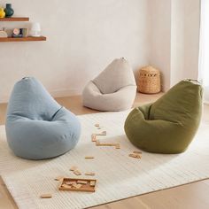 two bean bags sitting on top of a white rug next to each other in a living room