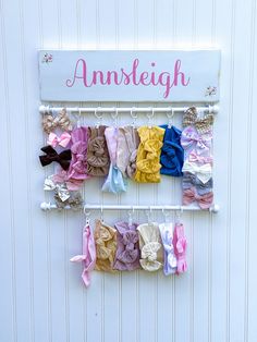 there are many different bows hanging on the hooks in front of the door that says, ansteeigh