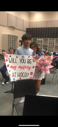 a boy and girl holding up a sign that says will you be my mommy at hoo?