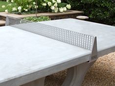 an outdoor table and chairs with white flowers in the backgrouds behind it