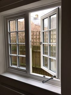 an open window in a room with white walls and wood trimming on the windowsill