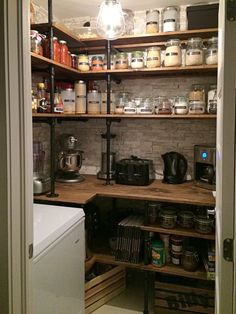 an open pantry with lots of jars and other items on the shelves, including a coffee maker