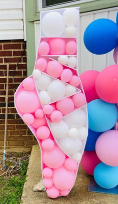 some balloons are in the shape of a boat and one is pink, blue, and white