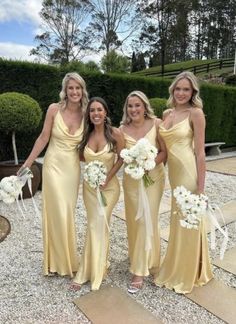 the bridesmaids are dressed in yellow dresses and holding white bouquets, all smiling for the camera