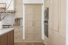 a kitchen with white cabinets and wood floors