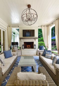 a living room with wicker furniture and a chandelier hanging from the ceiling