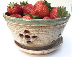 a bowl filled with strawberries on top of a table