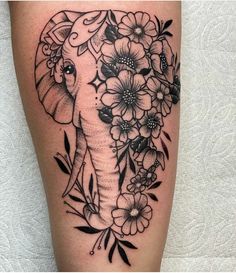 an elephant and flowers tattoo on the leg