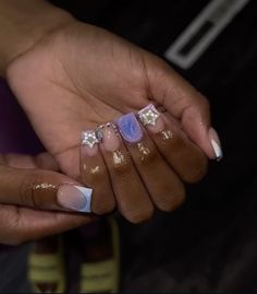 a woman holding out her hands with gold and white nails