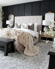 a bedroom with black walls, white bedding and an area rug on the floor