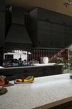 a kitchen with an island and counter top next to a potted plant on the counter