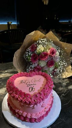 two heart shaped cakes on a table with flowers in the center and congratulations written on top