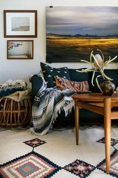 a living room filled with furniture and pictures hanging on the wall above it's coffee table