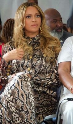 a woman sitting next to a man in a crowd