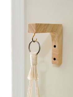 a key chain hanging from a hook on a white wall next to a wooden door