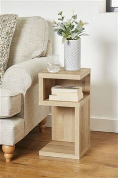 a living room with a couch, chair and side table on the hardwood flooring