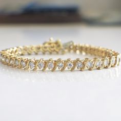 This diamond s link tennis bracelet is a classic staple for any jewelry collection! The diamonds are set in 18k yellow gold and circle the entire bracelet. Metal: 18K Yellow Gold Diamonds: 2.25 CTW SI2-I1 G-H Length: 7.25 For a greater selection of jewelry please visit our website at www.BlackMarketLLC.com If you have any questions about this product or if we can help you with any of our other products please contact us through Etsy or our website at www.BlackMarketLLC.com Each piece of our jewe Timeless Round Gold Bracelet With Cubic Zirconia, Anniversary Yellow Gold Diamond Bracelet With Prong Setting, Classic Yellow Gold Tennis Bracelet With Diamond Accents, Yellow Gold Tennis Bracelet With Diamond Accents For Anniversary, Anniversary Yellow Gold Tennis Bracelet With Diamond Accents, Timeless Round Cut Gold Bracelet For Anniversary, Elegant Yellow Gold Tennis Bracelet For Anniversary, Diamond White 14k Gold Tennis Bracelet, Timeless Diamond Accents Tennis Bracelet For Anniversary