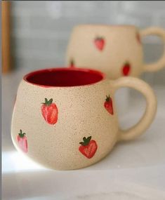 two ceramic mugs with strawberries painted on them