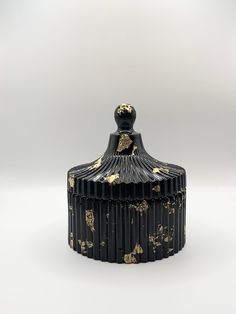 an ornate black and gold covered jar