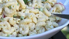 a white bowl filled with macaroni and cheese on top of a black table