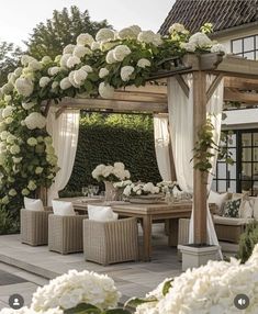 an outdoor dining area with white flowers and greenery