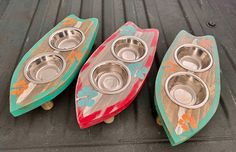 three wooden surfboards with metal bowls on them