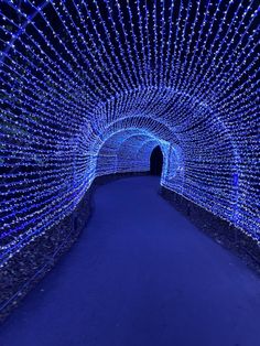 a tunnel that has lights all over it and is lit up with blue lights in the middle