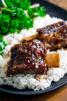 some meat and rice on a black plate