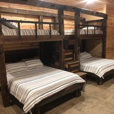 two bunk beds in a room with wooden walls and flooring, one is made out of pallets