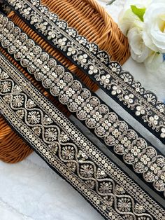 three different types of beaded belts sitting on top of a table next to flowers