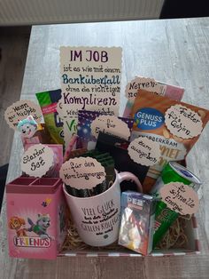 a box filled with lots of different items on top of a wooden table next to a sign